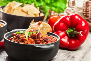 Bowls of hot chili con carne with ground beef, beans, tomatoes and corn