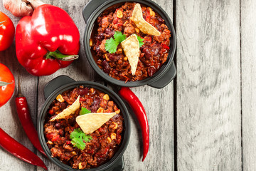Bowls of hot chili con carne with ground beef, beans, tomatoes a