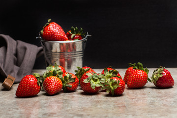 Fresas sobre encimera gris fondo negro vista de frente. Copy space