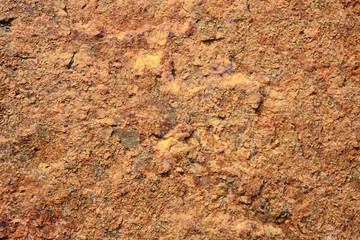Pattern of surface of a red stone. Texture of stone in a natural environment. A granite stone