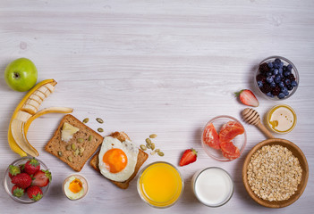 Naklejka na ściany i meble Breakfast served with coffee, orange juice, cereals, milk, fruits, eggs and toasts. Balance diet, food banner, background. View from above, top