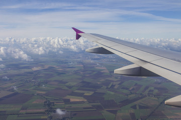 The wing of the plane in flight over the city