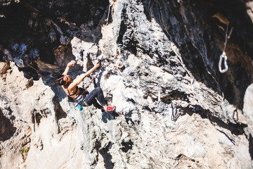 A woman climbs the rock.