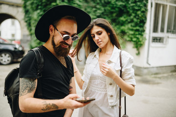 Communication and fun. Happy couple with smart phone. People standing outdoors together and looking at the mobile phone together