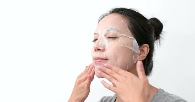 Woman apply paper mask sheet on face