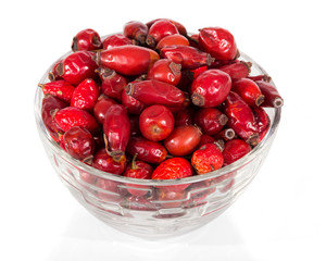 Dry rose hip fruits in glass bowl isolated on white
