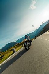 Fototapeta premium Motorcycle driver riding japanese high power cruiser in Alpine highway on famous Hochalpenstrasse, Austria.