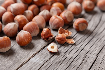 Heap Hazel and two nuts with  broken shell on an old wooden table.