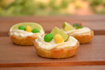 Sweet creamy cakes with lime on wooden table decoration