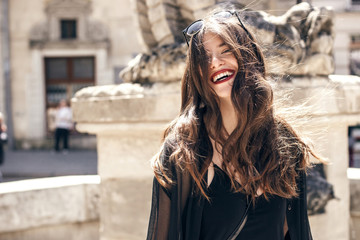 happy stylish woman with gorgeous smile and hair, having fun in sunlight in city street. beautiful...