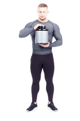 Full-length portrait of male fitness instructor holding container with sports nutrition on white background
