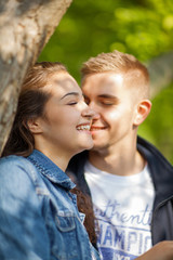 Young couple having fun, talking, flirting in a sunny park in springtime, beautiful, romantic mood