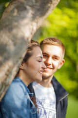 Fototapeta premium Young couple having fun, talking, flirting in a sunny park in springtime, beautiful, romantic mood