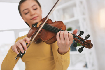 Conscious violinist. Delighted girl being relaxed while playing favorite melody