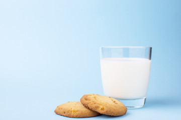 glass of milk and cookies on a blue background - obrazy, fototapety, plakaty