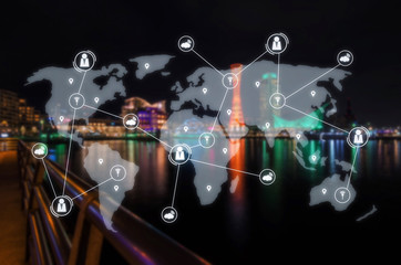 blurred image of beautiful view of Port of Kobe Tower at night in Kansai, Osaka, Japan with virtual interface icon, world map network connection diagram, internet, social media and technology concept