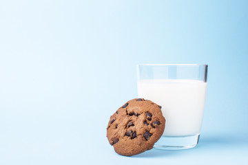 glass of milk and a school chocolate biscuit on a blue background
