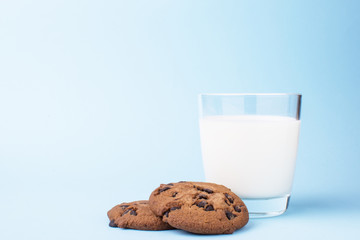 glass of milk and a school chocolate biscuit on a blue background