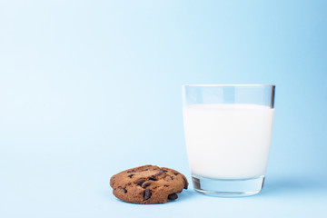 glass of milk and a school chocolate biscuit on a blue background