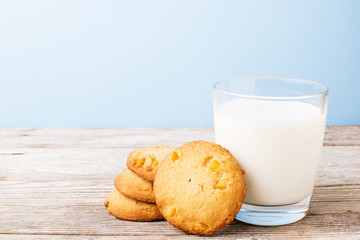 cookies and a glass of milk on a light table, on a blue background