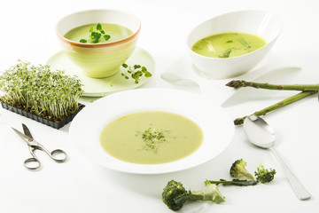Broccolicreme-Suppe mit frischer Kresse, Spargelcreme-Suppe und Kräutersuppe auf weissem Hintergrund