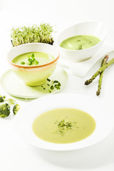 Broccolicreme-Suppe mit frischer Kresse, Spargelcreme-Suppe und Kräutersuppe auf weissem Hintergrund