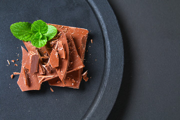 Chocolate on dark stone background. Top view with copy space.
