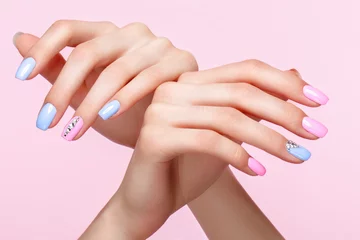 Photo sur Plexiglas ManIcure Belle manucure rose et bleue avec des cristaux sur la main féminine. Fermer. Photo prise en studio