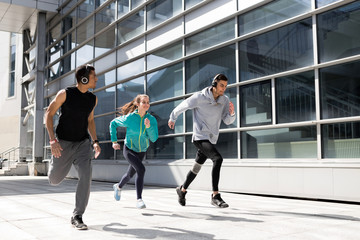 Young people go in for sports in the city. Running in the city. Friends are running around town