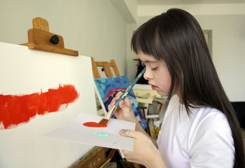 Naklejka premium Cute little girl is painting picture