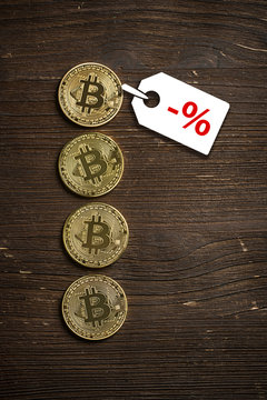 Bitcoin Münzen auf Holzuntergrund mit Preisnachlass-Hinweis