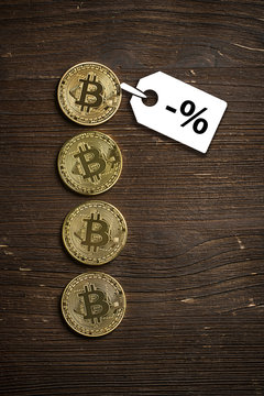 Bitcoin Münzen auf Holzuntergrund mit Preisnachlass-Hinweis