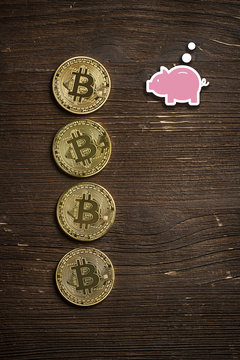 Bitcoin Münzen auf Holzuntergrund mit Sparschweinsymbol 