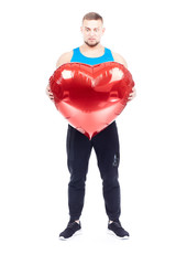 Portrait of athlete holding big red heart-shaped balloon isolated on white