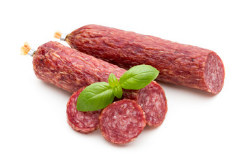 Salami smoked sausage, basil leaves and peppercorns isolated on white background.