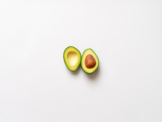 Avocado sliced with seed isolated in white background viewed from above - flatlay look