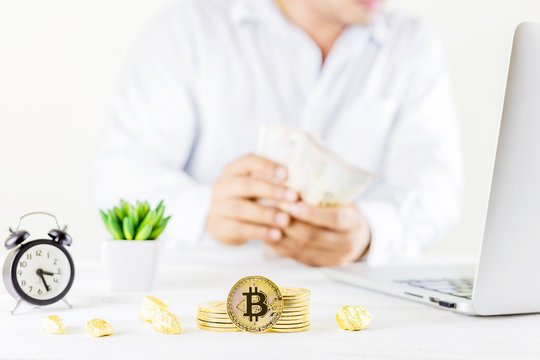 Bitcoin coin golden coin in the glass jar on wooden table ,Man trading cryptocurrency or bitcion.