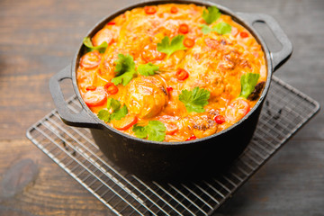 Creamy South Indian style Roast Chocken Curry on black pot on dark blue wooden rustic table