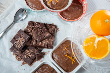 close up of dark chocolate mousse with tablets and oranges
