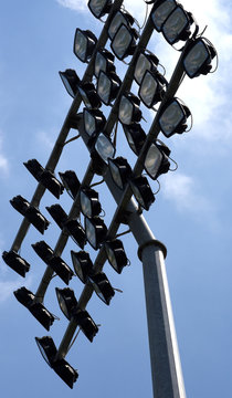 Flutlichtanlage im Stadion vor leuchtend blauem Himmel