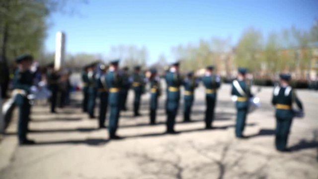 Military band plays music on the victory parade. Out of focus, blurred image.  Military parade of the armed forces, the removal of the banner of victory on the area of the military unit