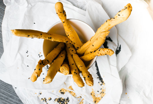 homemade snack, baked sticks with sesame and black cumin in the paper cup. Cristy sticks with sesaam and cumin seeds