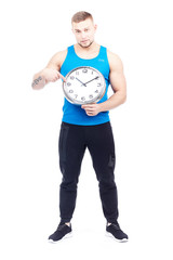 Full-length portrait of fit athlete holding wall clock on white background