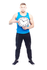 Full-length portrait of fit athlete holding wall clock on white background