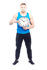 Full-length portrait of fit athlete holding wall clock on white background