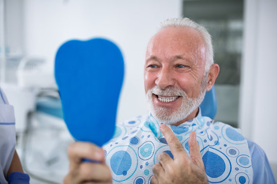 Dentist With Sterile Mask And Dental Instruments Held Exam Teeth Of Patient