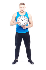 Full-length portrait of fit athlete holding wall clock on white background