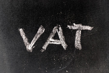 White chalk drawing in VAT (Value added tax) on black board background