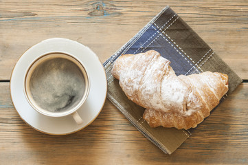 Coffee and croissants on the wood.