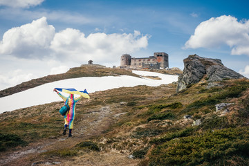 Traveling to Ukraine. Hiker with Ukrainian flag in Carpathians mountains